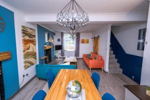 a dining room and living room with a table and blue walls at Happy Days Afan Forest in Cymmer