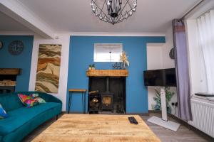 sala de estar con sofá y chimenea en Happy Days Afan Forest en Cymmer