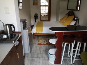 ein Schlafzimmer mit Bett und eine Küche mit Tisch in der Unterkunft Lotus Guest House in Johannesburg