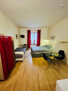 a bedroom with two beds and a table and chairs at Ludotel in Belley