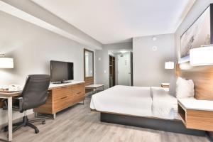 um quarto de hotel com uma cama e uma secretária com um computador em Admiral Inn Mississauga em Mississauga