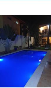 a blue swimming pool in a yard at night at Panorama Cumbuco in Cumbuco