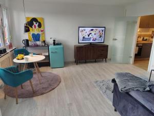 a living room with a couch and a table and a tv at Stylisches Apartment im Szene-Viertel Ehrenfeld in Cologne