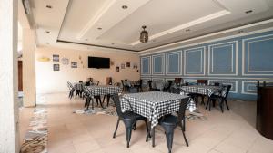 un restaurante con mesas y sillas en blanco y negro en HOTEL SAPTA GRIA en Jetis