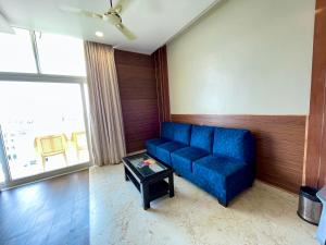 a living room with a blue couch and a table at Hotel TBS - all-rooms-sea-view, Swimming-pool, fully-air-conditioned-hotel with-lift-and-parking-facility breakfast-included in Puri