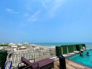 a view of a swimming pool and the beach at Hotel TBS - all-rooms-sea-view, Swimming-pool, fully-air-conditioned-hotel with-lift-and-parking-facility breakfast-included in Puri