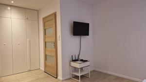 a white room with a television on a wall at Perfect Location Comfort Apartment City Beat#10 in Krakow