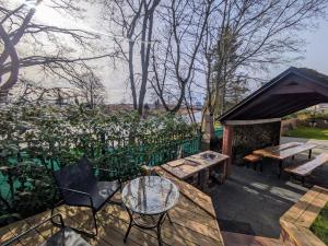 eine Terrasse mit einem Tisch, Bänken und einem Grill in der Unterkunft SB Apartment in Kołobrzeg