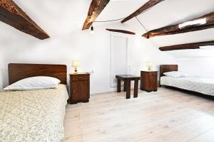 2 łóżka w pokoju z drewnianym sufitem i drewnianą podłogą w obiekcie Apartman studio Baladur w mieście Roč
