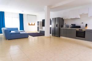 a living room with a blue couch and a kitchen at CASA PARI in Playa Blanca