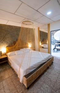 a bedroom with a large bed with a net at Ambos Mundos Hotel Boutique in Taganga