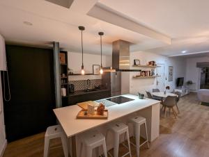 een keuken en een woonkamer met een groot eiland met krukken bij APARTAMENTO RECONQUISTA in Toledo