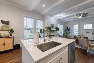 a kitchen with a sink and a living room at Greenhouse Uptown in Dallas