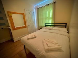 una camera da letto con un letto e due asciugamani di Anwar House a Londra