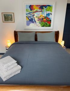 a blue bed with two towels on top of it at Villa Amahe - Chambres d'hôtes au coeur de Piriac sur Mer in Piriac-sur-Mer