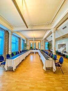 um grande salão de banquetes com mesas e cadeiras longas em Hotel Le Dome em Bruxelas