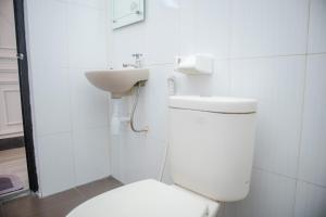 La salle de bains blanche est pourvue de toilettes et d'un lavabo. dans l'établissement KAZAIN HOTEL, à Timuran