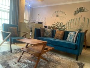 a living room with a blue couch and two chairs at Barryston Haven 1 in Kampala