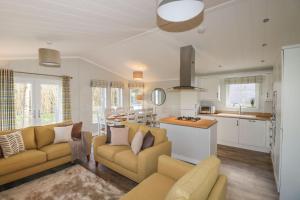a living room with two couches and a kitchen at 23 Meadow Retreat in Liskeard