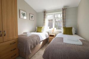 a small bedroom with two beds and a window at 23 Meadow Retreat in Liskeard