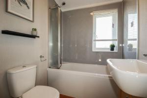 a bathroom with a toilet and a tub and a sink at 23 Meadow Retreat in Liskeard +21 photos