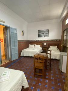 a hotel room with two beds and a table at Tranvía Beach House in Chipiona