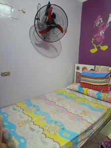 a bedroom with a bed with a fan on the wall at شقه فندقيه in ‘Ezbet el-Insha