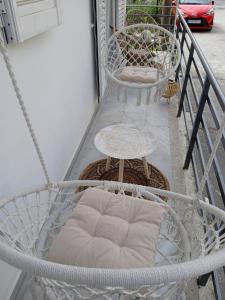 a white porch swing with a chair and a table at Mirto Luxury Appartment in Heraklio Town