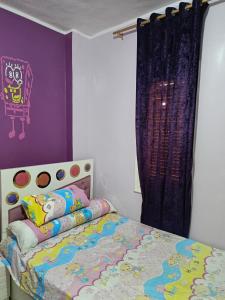 a bedroom with a bed and a purple wall at شقه فندقيه in ‘Ezbet el-Insha