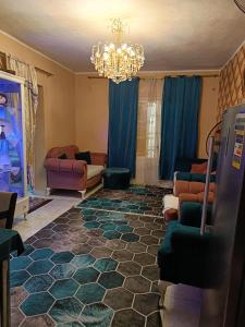 een woonkamer met een kroonluchter en een bank bij شقه فندقيه in ‘Ezbet el-Insha