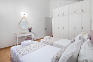 a bedroom with two beds and a mirror at Kalami Lookout Villa in Kalami