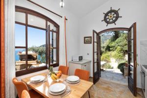 a kitchen and dining room with a wooden table and chairs at Kalami Lookout Villa in Kalami