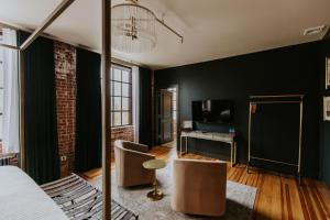 a bedroom with black walls and a bed and chairs at HATCHERY HOTEL & EVENT CENTER in La Crosse