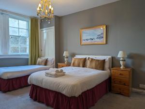1 dormitorio con 2 camas y lámpara de araña en The Georgian House en Glasgow