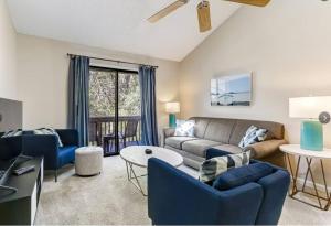 a living room with a couch and blue chairs at Beach Escape, 1 block from the Beach in Fernandina Beach