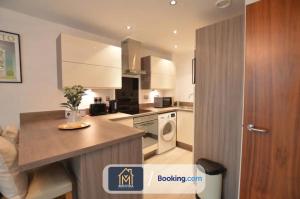 a kitchen with a counter and a stove top oven at Beautiful Apartment Next To LGI By Movida Property Group Short Lets & Serviced Accommodation in Leeds