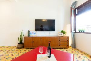 sala de estar con TV y mesa con copas de vino en La Casita del Malecón, en Murcia