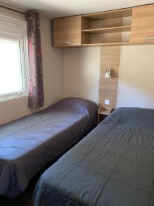a room with two beds and a window at Mobile Home Village Vacances Océan et Nature in Seignosse
