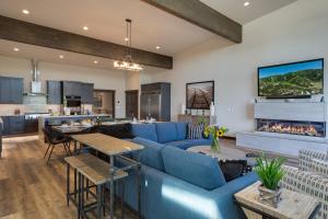 a living room with a blue couch and a fireplace at LUXURY SKI-IN-OUT Mid-Mountain Game Room Hot Tub in Whitefish