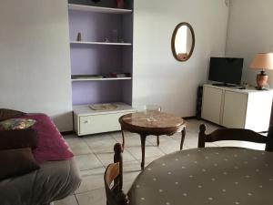 sala de estar con mesa y TV en Appartement Vals les bains, en Vals-les-Bains