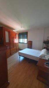 sypialnia z łóżkiem w pokoju z drewnianą podłogą w obiekcie Ría de Arousa w mieście Boiro