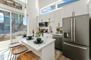 a kitchen with white cabinets and a refrigerator at Luxury Amenities with a Central Location to Downtown and Whitefish Mountain Resort in Whitefish