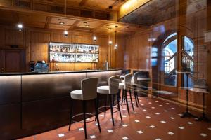 un bar con una fila de taburetes en un restaurante en Hotel Lechnerhof Unterföhring en Múnich