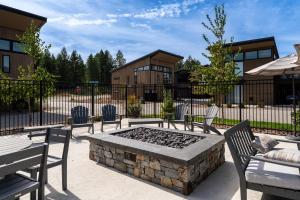 a patio with chairs and a fire pit in front of a fence at Luxury Amenities with a Central Location to Downtown and Whitefish Mountain Resort in Whitefish