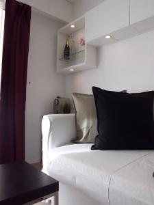 - un canapé blanc dans le salon avec une bouteille de vin dans l'établissement Monaco Beach Balcony Apartments, à Beausoleil