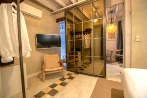 a room with a glass closet with a chair and a tv at Blue Sardine Hostal Boutique Altea Adults Only in Altea