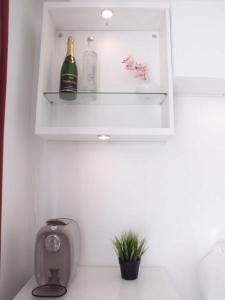 La salle de bains est pourvue d'un lavabo et d'une bouteille de champagne. dans l'établissement Monaco Beach Balcony Apartments, à Beausoleil