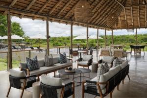un pabellón con sofás, sillas, mesas y sombrillas en Leopard Sands Kruger Park, en Skukuza