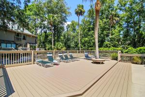 a deck with chairs and a table and a tree at Beachwalk 110 in Hilton Head Island