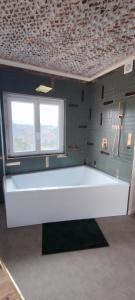 Habitación con una gran mesa blanca frente a una ventana en La petite maison d'Hose, en Monistrol-sur-Loire